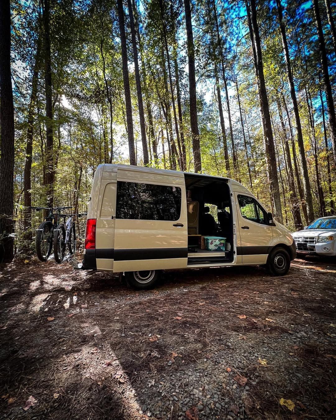 The van parked in the forest with bikes, ready for adventure